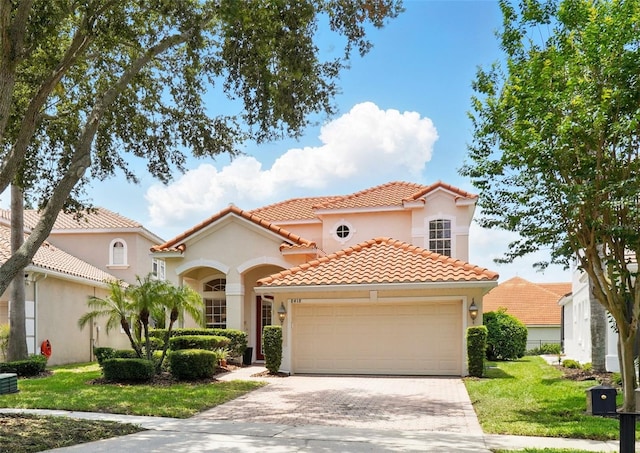 8418 Via Bella Notte, Orlando, FL 32836 - mediterranean / spanish house featuring a garage, stucco siding, a tiled roof, driveway, and a front lawn