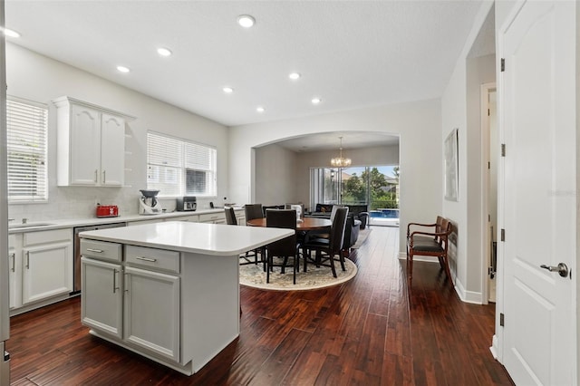 8418 Via Bella Notte, Orlando, FL 32836 - kitchen with arched walkways, a chandelier, dishwasher, dark wood-style floors, and light countertops