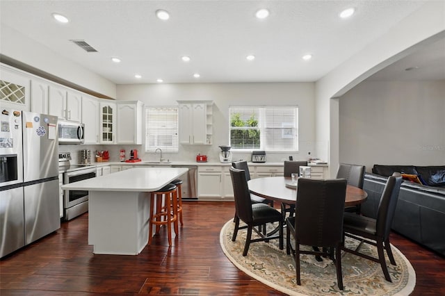 8418 Via Bella Notte, Orlando, FL 32836 - kitchen with stainless steel appliances, a breakfast bar, a center island, white cabinets, and recessed lighting