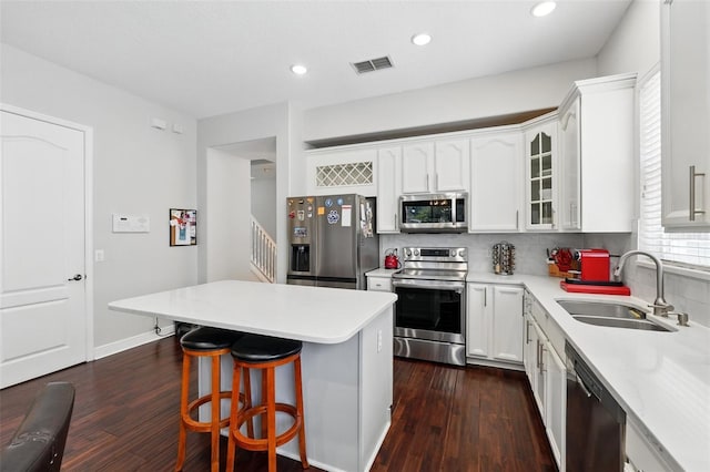 8418 Via Bella Notte, Orlando, FL 32836 - kitchen featuring stainless steel appliances, a sink, a breakfast bar area, dark wood-type flooring, and recessed lighting