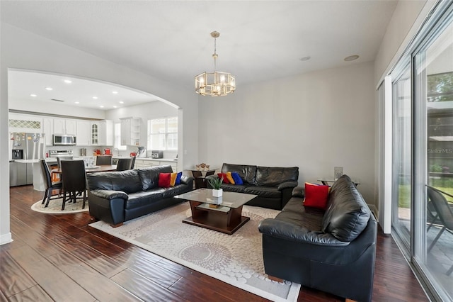 8418 Via Bella Notte, Orlando, FL 32836 - living room with arched walkways, dark wood-style flooring, a chandelier, and recessed lighting