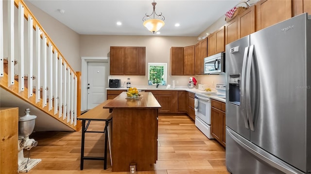 287 Hilltop Dr, Longwood, FL 32750 - kitchen with appliances with stainless steel finishes, light wood-style floors, a kitchen island, recessed lighting, and brown cabinets