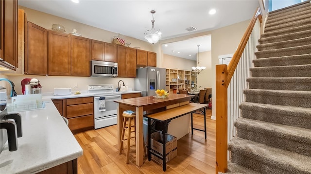 287 Hilltop Dr, Longwood, FL 32750 - kitchen with stainless steel appliances, light wood-style flooring, light countertops, a sink, and pendant lighting
