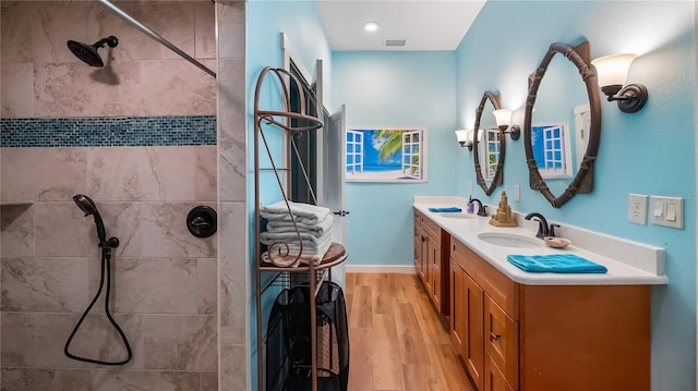 287 Hilltop Dr, Longwood, FL 32750 - full bathroom with double vanity, wood finished floors, tiled shower, and baseboards