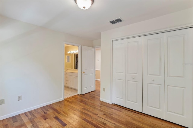 914 Elysium Blvd, Mount Dora, FL 32757 - unfurnished bedroom featuring a closet, light wood finished floors, and connected bathroom