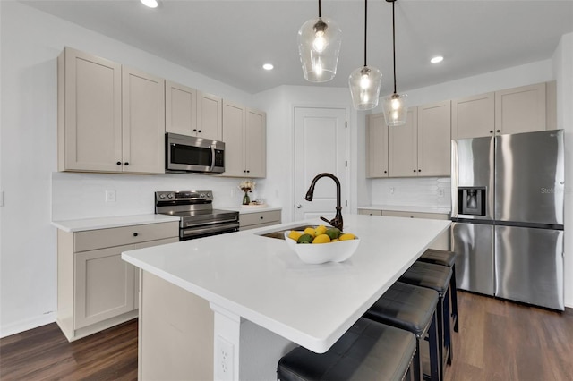 2210 Derwent Dr, Davenport, FL 33896 - kitchen with appliances with stainless steel finishes, a sink, dark wood-type flooring, a kitchen bar, and recessed lighting