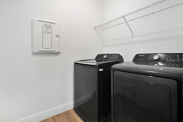 3280 Canna Lily Pl, Clermont, FL 34711 - laundry room with washing machine and clothes dryer, baseboards, light wood-style floors, and electric panel
