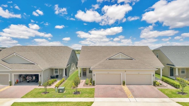 3280 Canna Lily Pl, Clermont, FL 34711 - view of front of property with decorative driveway, stucco siding, roof with shingles, and a front lawn