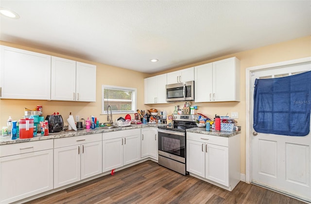 660 6th St, Daytona Beach, FL 32117 - kitchen featuring stainless steel appliances, recessed lighting, white cabinetry, dark wood finished floors, and a sink