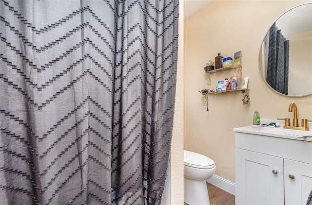 660 6th St, Daytona Beach, FL 32117 - bathroom with vanity, wood finished floors, toilet, baseboards, and a shower with curtain