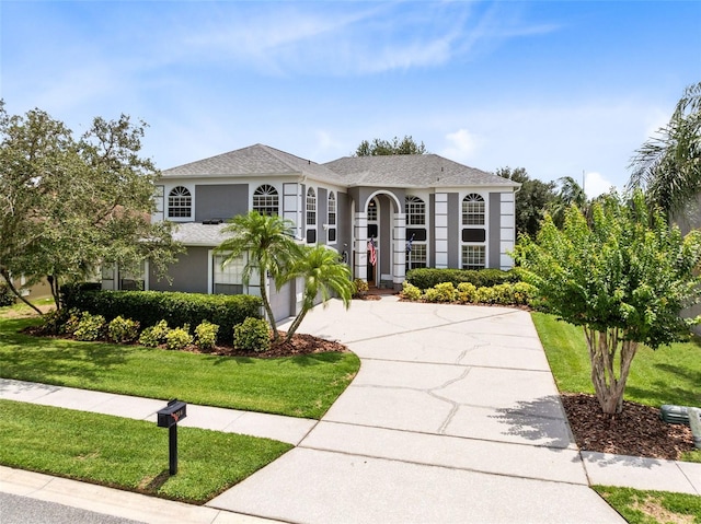 2214 Westbourne Dr, Oviedo, FL 32765 - view of front of property featuring concrete driveway, a front lawn, stucco siding, and roof with shingles