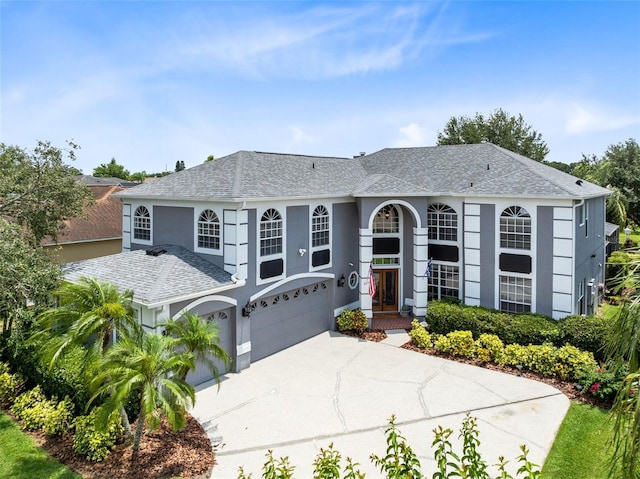 2214 Westbourne Dr, Oviedo, FL 32765 - view of front of property featuring roof with shingles, an attached garage, driveway, and stucco siding