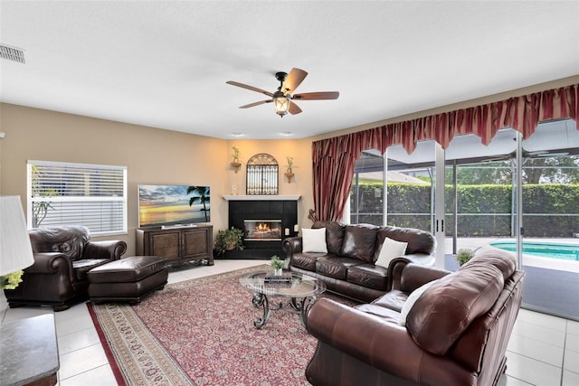 2214 Westbourne Dr, Oviedo, FL 32765 - living room featuring light tile patterned flooring, a ceiling fan, and a tile fireplace
