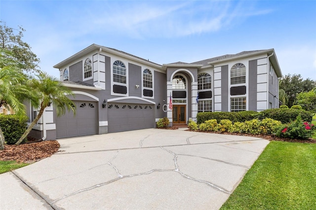 2214 Westbourne Dr, Oviedo, FL 32765 - view of front of house with stucco siding, a garage, french doors, and concrete driveway