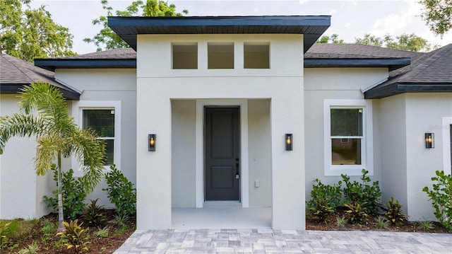 1331 19th St, Orlando, FL 32805 - view of exterior entry featuring a shingled roof and stucco siding