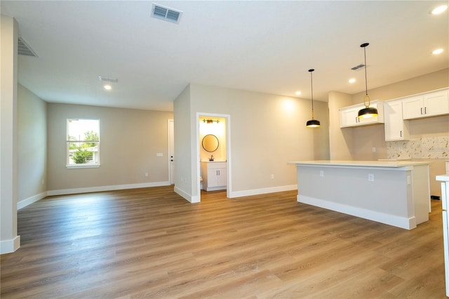 1331 19th St, Orlando, FL 32805 - kitchen with recessed lighting, white cabinetry, baseboards, and light wood-type flooring