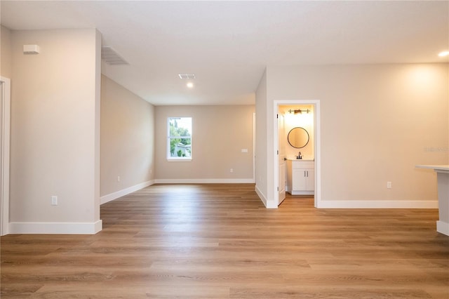 1331 19th St, Orlando, FL 32805 - spare room featuring light wood-style floors, baseboards, recessed lighting, and a sink