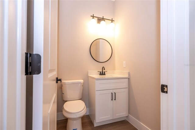 1331 19th St, Orlando, FL 32805 - bathroom with vanity, toilet, baseboards, and wood finished floors