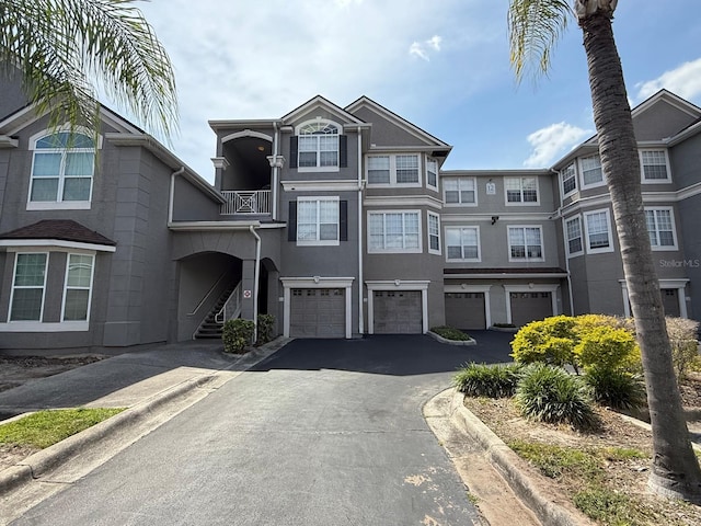 3391 S Kirkman Rd Unit 1236, Orlando, FL 32811 - view of property featuring an attached garage, driveway, and stucco siding