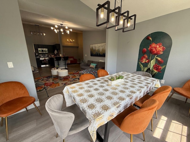 3391 S Kirkman Rd Unit 1236, Orlando, FL 32811 - dining space featuring a chandelier, wood finished floors, lofted ceiling, and baseboards