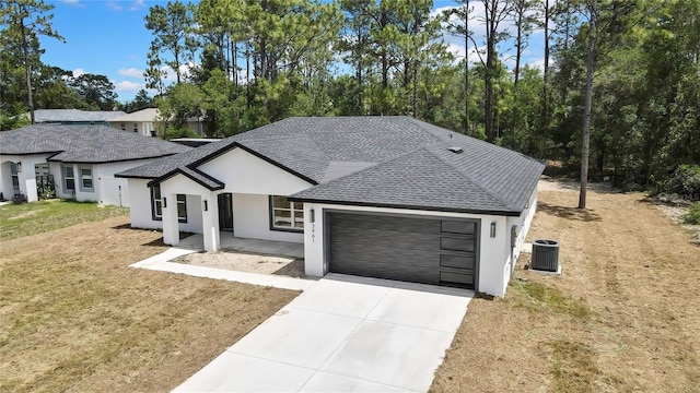 3461 W Webster Pl, Citrus Springs, FL 34433 - view of front of house featuring roof with shingles, central AC, a garage, and stucco siding