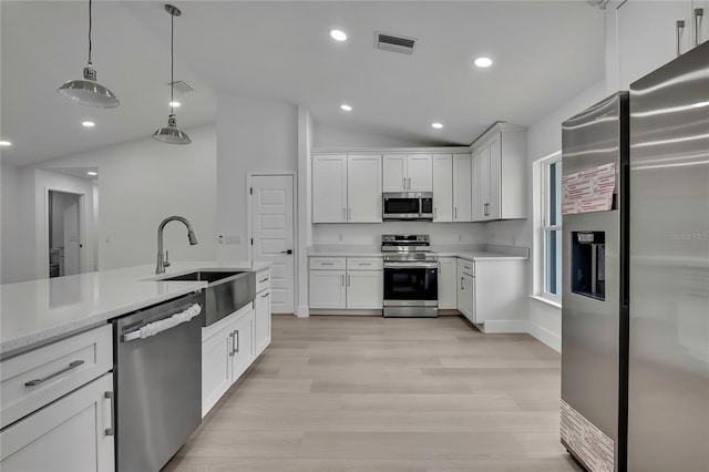 3461 W Webster Pl, Citrus Springs, FL 34433 - kitchen featuring stainless steel appliances, a sink, lofted ceiling, white cabinetry, and light wood-style flooring