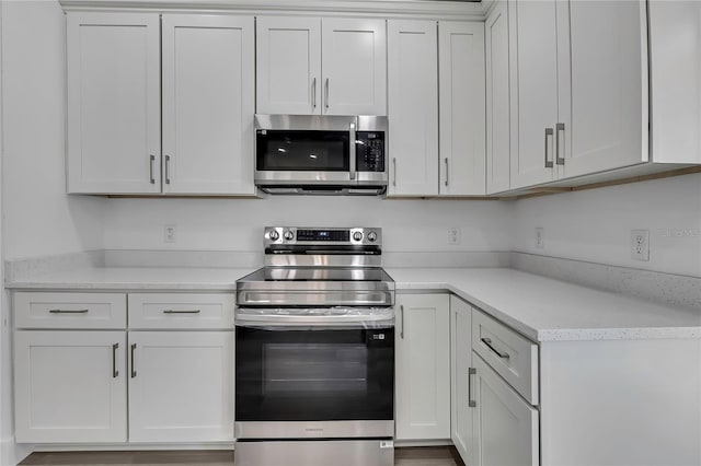 3461 W Webster Pl, Citrus Springs, FL 34433 - kitchen featuring appliances with stainless steel finishes, light countertops, and white cabinets