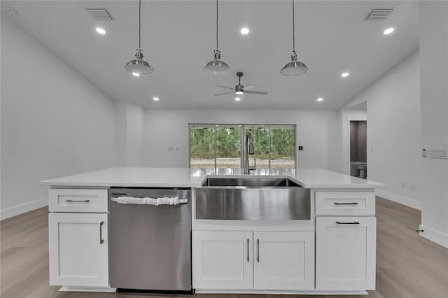 3461 W Webster Pl, Citrus Springs, FL 34433 - kitchen with stainless steel dishwasher, a sink, light wood-type flooring, vaulted ceiling, and white cabinets