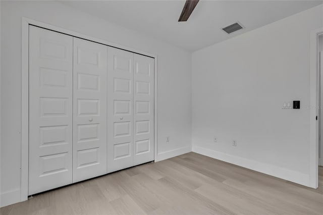 3461 W Webster Pl, Citrus Springs, FL 34433 - unfurnished bedroom featuring light wood-style flooring, baseboards, a closet, and a ceiling fan