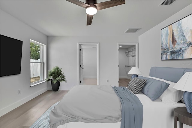 3461 W Webster Pl, Citrus Springs, FL 34433 - bedroom with a spacious closet, light wood-style flooring, baseboards, and ceiling fan