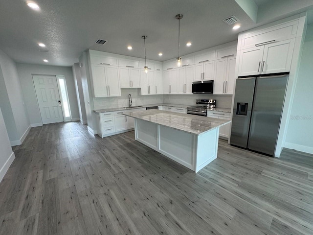 9 Bunker Pl, Rotonda West, FL 33947 - kitchen featuring stainless steel appliances, baseboards, white cabinets, a kitchen island, and recessed lighting