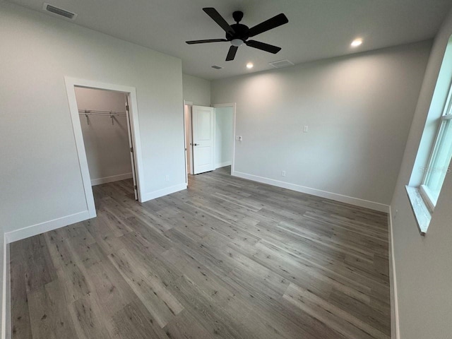 9 Bunker Pl, Rotonda West, FL 33947 - unfurnished bedroom with wood finished floors, recessed lighting, baseboards, a walk in closet, and ceiling fan