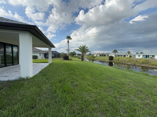 9 Bunker Pl, Rotonda West, FL 33947 - view of grassy yard featuring a water view, a patio, and a residential view