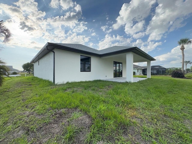 9 Bunker Pl, Rotonda West, FL 33947 - back of house featuring stucco siding, a patio area, and a yard
