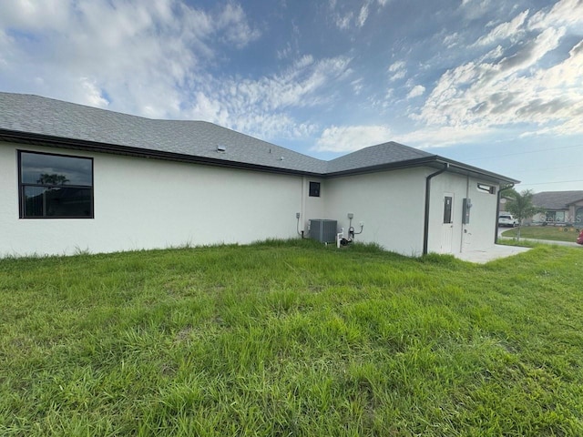 9 Bunker Pl, Rotonda West, FL 33947 - rear view of house with stucco siding and a yard
