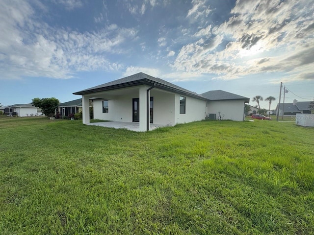 9 Bunker Pl, Rotonda West, FL 33947 - rear view of house featuring a patio, stucco siding, a yard, and central air condition unit