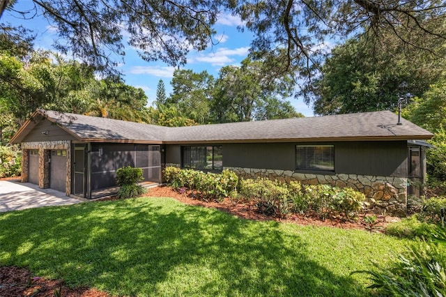 1343 Charlotte St, Altamonte Springs, FL 32701 - view of front of house with stone siding, an attached garage, a front yard, a sunroom, and driveway