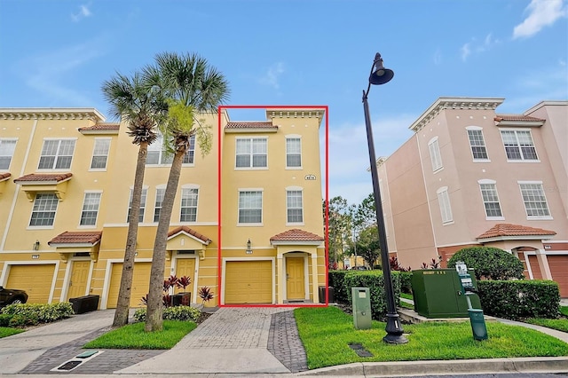 4816 Tidecrest Ave Unit 178, Orlando, FL 32819 - view of front of home with driveway, stucco siding, an attached garage, and a tiled roof
