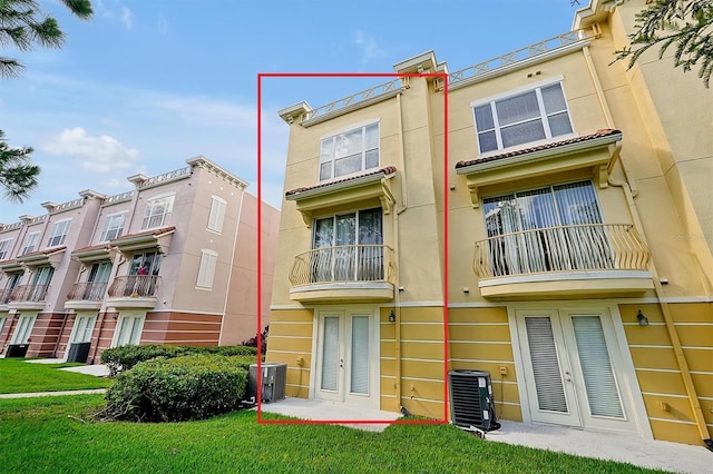 4816 Tidecrest Ave Unit 178, Orlando, FL 32819 - rear view of house featuring french doors, central air condition unit, stucco siding, and a yard