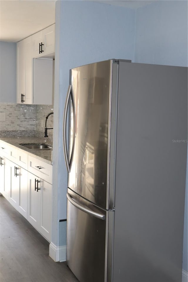 1212 Leon Ln, Daytona Beach, FL 32117 - kitchen with freestanding refrigerator, a sink, dark stone countertops, dark wood-style flooring, and decorative backsplash