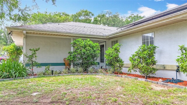 2771 NE 66th St, Ocala, FL 34479 - doorway to property with stucco siding, a lawn, and roof with shingles