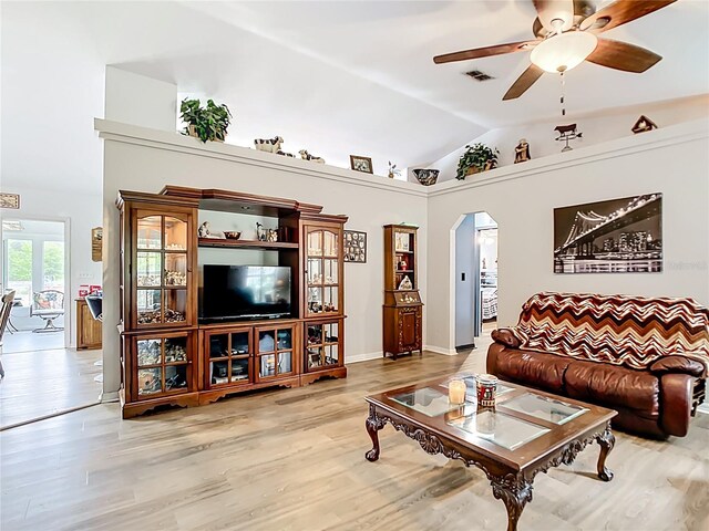 2771 NE 66th St, Ocala, FL 34479 - living area with vaulted ceiling, arched walkways, a ceiling fan, and light wood-type flooring