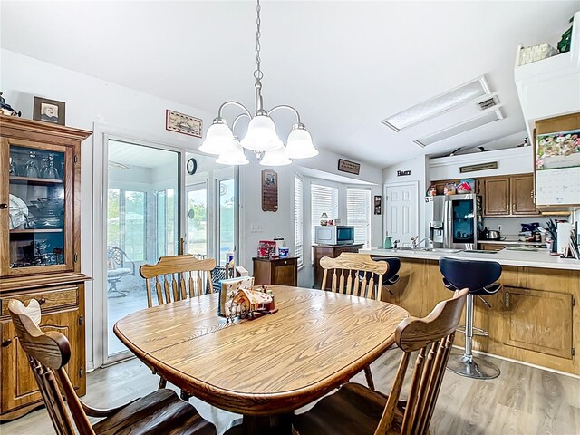 2771 NE 66th St, Ocala, FL 34479 - dining space with light wood finished floors, vaulted ceiling, and a chandelier