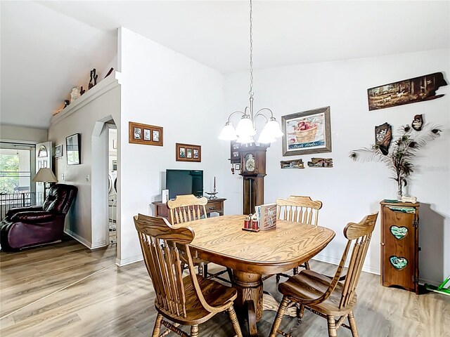 2771 NE 66th St, Ocala, FL 34479 - dining space with vaulted ceiling, light wood-type flooring, baseboards, and a chandelier