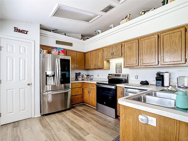 2771 NE 66th St, Ocala, FL 34479 - kitchen featuring stainless steel appliances, brown cabinets, light wood-style flooring, light countertops, and a sink