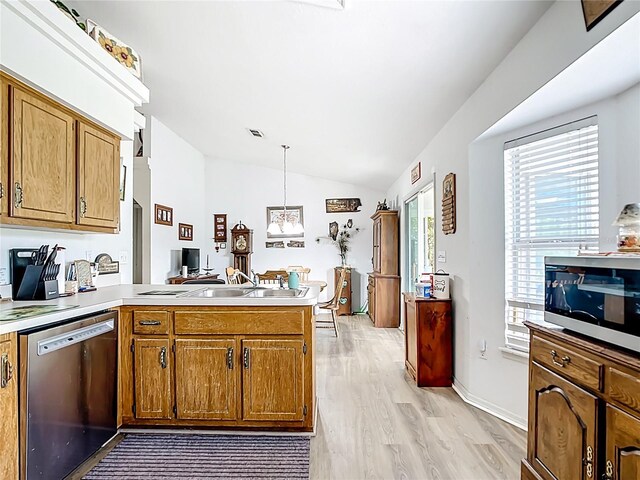 2771 NE 66th St, Ocala, FL 34479 - kitchen with stainless steel appliances, a peninsula, lofted ceiling, light wood-style floors, and brown cabinetry
