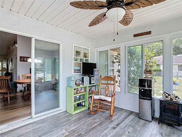 2771 NE 66th St, Ocala, FL 34479 - sunroom / solarium with a wood stove, wood finished floors, a textured wall, and wooden ceiling