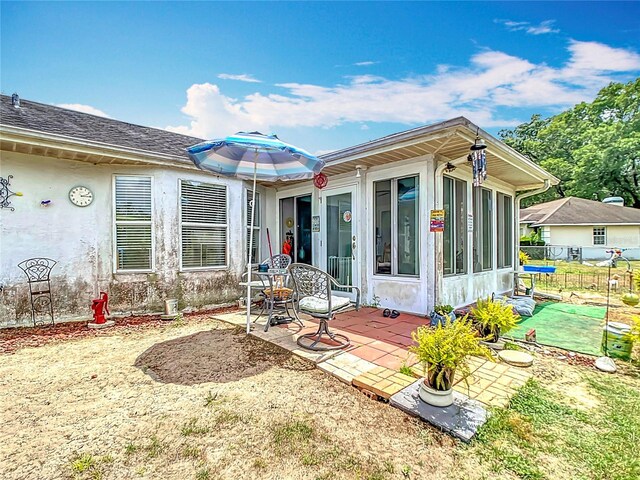2771 NE 66th St, Ocala, FL 34479 - rear view of house with a patio, a sunroom, and stucco siding