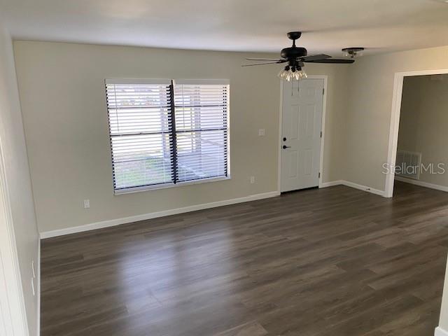 1750 Mitten Ter, Deltona, FL 32738 - spare room with dark wood finished floors, a ceiling fan, and baseboards