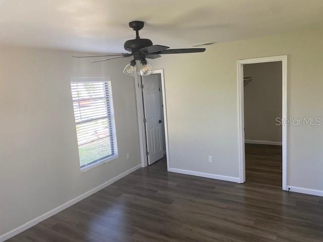 1750 Mitten Ter, Deltona, FL 32738 - unfurnished bedroom featuring dark wood finished floors, baseboards, and a walk in closet